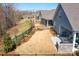 Partially seeded backyard with mulch, brick fire place, and black metal fence at 5025 Antebellum Dr, Iron Station, NC 28080