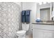 Clean bathroom with blue patterned shower curtain, granite counter, and blue towel set at 5025 Antebellum Dr, Iron Station, NC 28080