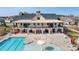 Aerial view of clubhouse with stone accents, upper balcony, and spacious pool area, inviting for leisure activities at 5025 Antebellum Dr, Iron Station, NC 28080