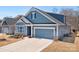 Charming blue two-story home with a two-car garage and meticulously maintained lawn at 5025 Antebellum Dr, Iron Station, NC 28080
