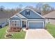 Charming blue two-story home featuring a two-car garage and beautifully landscaped front yard at 5025 Antebellum Dr, Iron Station, NC 28080