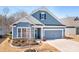 Charming blue two-story home featuring a two-car garage and a landscaped front yard at 5025 Antebellum Dr, Iron Station, NC 28080