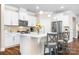 Modern kitchen with white cabinets, stainless steel appliances, and a breakfast bar with seating at 5025 Antebellum Dr, Iron Station, NC 28080