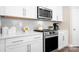 Well-lit kitchen featuring white cabinets, stainless steel appliances, and a stylish backsplash at 5025 Antebellum Dr, Iron Station, NC 28080