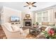 Cozy living room with a stone fireplace, ceiling fan, and comfortable seating arrangement near a window at 5025 Antebellum Dr, Iron Station, NC 28080