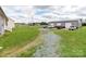 Rear view of the property showing a long gravel driveway leading to a detached garage and parking area at 514 Baucom Deese Rd, Monroe, NC 28110
