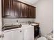 Convenient laundry room features matching dark cabinets and utility sink at 514 Baucom Deese Rd, Monroe, NC 28110