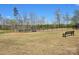 Community common area with shade trees, bench seating, and black metal fencing at 525 Cellini Pl, Mount Holly, NC 28120