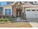 Close up showing stone facade, walkway and trimmed shrubs at entrance to home and two-car garage at 525 Cellini Pl, Mount Holly, NC 28120