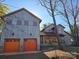 Unique exterior with a two-car garage, wooden siding, and colorful accents for a charming look at 525 Cellini Pl, Mount Holly, NC 28120