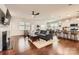 Open-concept living room with hardwood floors, fireplace, and seamless connection to the kitchen and dining area at 525 Cellini Pl, Mount Holly, NC 28120