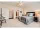Bright main bedroom featuring neutral walls, ceiling fan, and access to the bathroom and closet at 525 Cellini Pl, Mount Holly, NC 28120