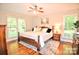 Tranquil main bedroom featuring large windows, hardwood floors, and a decorative ceiling fan at 5344 Saddlewood Ln, Mint Hill, NC 28227