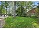 Picturesque backyard with mature trees, a grassy lawn, and charming garden shed at 5400 Glenham Dr, Charlotte, NC 28210