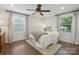 Cozy bedroom with neutral colors, carpet, large windows, a ceiling fan and ample natural light creates a warm and inviting space at 5400 Glenham Dr, Charlotte, NC 28210