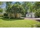 Exterior view showcasing a home with lush landscaping, charming details, and a detached garage, perfect for curb appeal at 5400 Glenham Dr, Charlotte, NC 28210