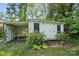 White detached garage with double doors, accompanied by flourishing vegetation and plants surrounding its perimeter at 5400 Glenham Dr, Charlotte, NC 28210