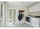 Bright laundry room with washer, dryer, and convenient access to the outside through a set of elegant french doors at 5400 Glenham Dr, Charlotte, NC 28210