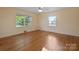 Bright bedroom featuring two windows, hardwood floors, light yellow walls and a ceiling fan at 631 Dogwood Rd, Statesville, NC 28677