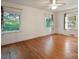 Sunlit bedroom with hardwood floors, white walls, and two windows overlooking the landscaped exterior at 631 Dogwood Rd, Statesville, NC 28677