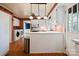 Bright kitchen with laundry area, white cabinets, hardwood flooring and stainless steel trash receptacle at 631 Dogwood Rd, Statesville, NC 28677