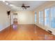 Sun-filled living room featuring hardwood floors, shuttered windows, neutral walls, and a ceiling fan at 631 Dogwood Rd, Statesville, NC 28677