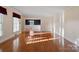 Open living room with hardwood floors transitions into dining area with elegant lighting fixture and wainscoting at 631 Dogwood Rd, Statesville, NC 28677