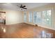 Bright living room with hardwood floors, neutral walls, ceiling fan and large windows with white shutters at 631 Dogwood Rd, Statesville, NC 28677