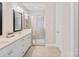 Bright bathroom features double vanity, a glass-enclosed shower, and neutral tile flooring at 650 Tallulah Falls Dr, Denver, NC 28037