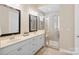 Bathroom with double sink vanity, framed mirrors, and a glass-enclosed shower with a bench at 650 Tallulah Falls Dr, Denver, NC 28037