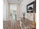 Hallway featuring hardwood floors and neutral paint, leading to the living area and offering plenty of natural light at 650 Tallulah Falls Dr, Denver, NC 28037
