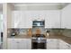 Bright kitchen features granite countertops, white cabinetry, and stainless steel appliances at 650 Tallulah Falls Dr, Denver, NC 28037