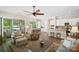 Open-concept living space with a ceiling fan, patio access, and a view of the kitchen with a breakfast bar at 650 Tallulah Falls Dr, Denver, NC 28037