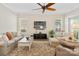 Living room features a ceiling fan, large windows, comfortable seating, and neutral decor at 650 Tallulah Falls Dr, Denver, NC 28037