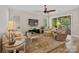 Bright living room featuring a ceiling fan, neutral paint, and access to the back patio via sliding glass doors at 650 Tallulah Falls Dr, Denver, NC 28037