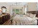 Comfortable bedroom with a ceiling fan, large windows, and a dresser with a mirror at 650 Tallulah Falls Dr, Denver, NC 28037