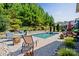 Relaxing backyard pool area with stone patio, green landscaping, and plenty of space for outdoor entertaining at 650 Tallulah Falls Dr, Denver, NC 28037