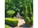 Stone outdoor fireplace area with seating and surrounding landscaping at 708 Ridgelake Dr, Weddington, NC 28104