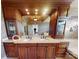 A bathroom with a double sink, brown cabinets, drawers, and a large mirror at 708 Ridgelake Dr, Weddington, NC 28104