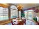 Sunlit dining area featuring a wooden table set for six, surrounded by large windows and a decorative chandelier at 708 Ridgelake Dr, Weddington, NC 28104