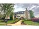 Stately two-story home with a stone chimney, manicured landscaping, and a welcoming front entrance at 708 Ridgelake Dr, Weddington, NC 28104
