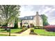 Charming two-story home with beautiful landscaping, a stone chimney, and a walkway to the front door at 708 Ridgelake Dr, Weddington, NC 28104