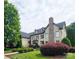 Beautiful two-story home featuring a stone chimney and lush landscaping in a well-manicured yard at 708 Ridgelake Dr, Weddington, NC 28104