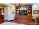 Cozy living room featuring custom built-in shelving, hardwood floors, and a comfortable chair at 708 Ridgelake Dr, Weddington, NC 28104
