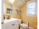 Bright half bathroom featuring a white vanity with a round mirror and toilet at 734 E 10Th St, Charlotte, NC 28202