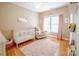 Cozy Bedroom with white crib, armchair, and natural light at 734 E 10Th St, Charlotte, NC 28202