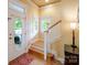 Inviting entryway featuring hardwood floors, stairs, and natural light from the oval glass door at 734 E 10Th St, Charlotte, NC 28202