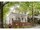 Attractive two-story home featuring a spacious front porch with white railings and a brick foundation at 734 E 10Th St, Charlotte, NC 28202