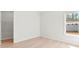 Cozy bedroom featuring light wood floors, a walk-in closet, and a window with a view of the backyard at 7500 Happy Hollow Dr, Mint Hill, NC 28227