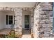 Stylish front entryway features a decorative glass door, stone archway, and tasteful landscaping at 7500 Happy Hollow Dr, Mint Hill, NC 28227
